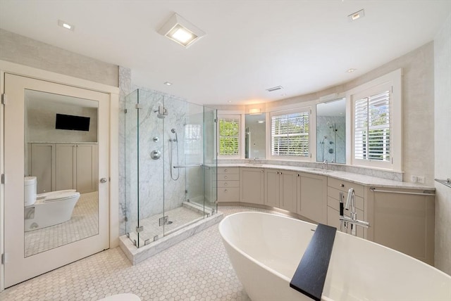 full bath featuring a shower stall, healthy amount of natural light, a soaking tub, and toilet