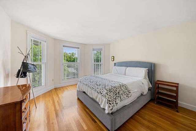 bedroom with light wood-type flooring and baseboards