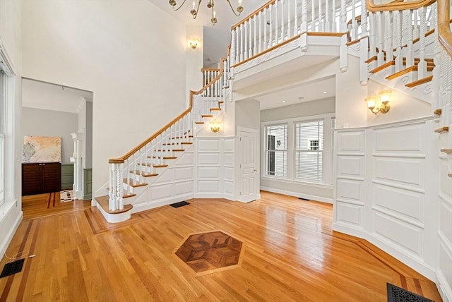 entrance foyer with stairway, a high ceiling, and wood finished floors
