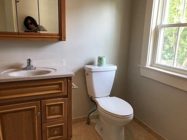 bathroom with baseboards, vanity, toilet, and tile patterned floors