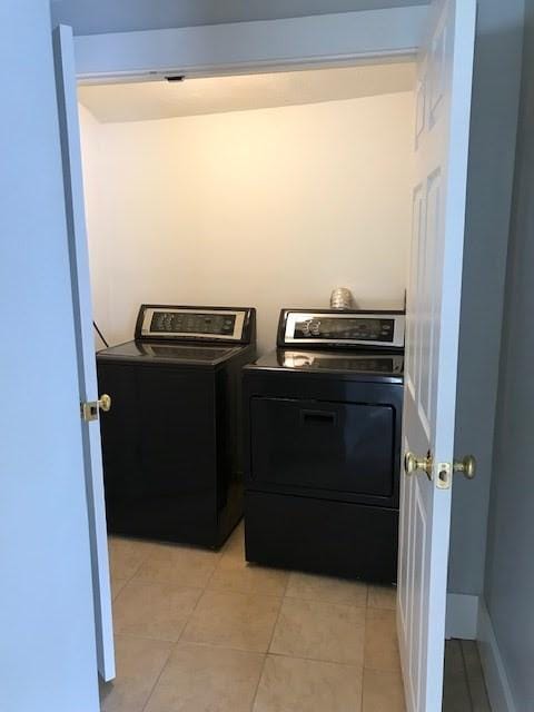 washroom featuring light tile patterned floors and washing machine and dryer