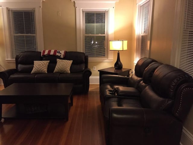 living room with dark wood-type flooring and baseboards