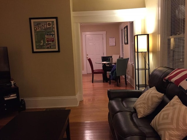 living area featuring baseboards and wood finished floors