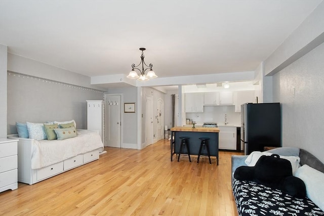 250 Beacon Unit 1B, Boston, MA 02116 - bedroom with freestanding refrigerator, a chandelier, light wood-style floors, and a sink