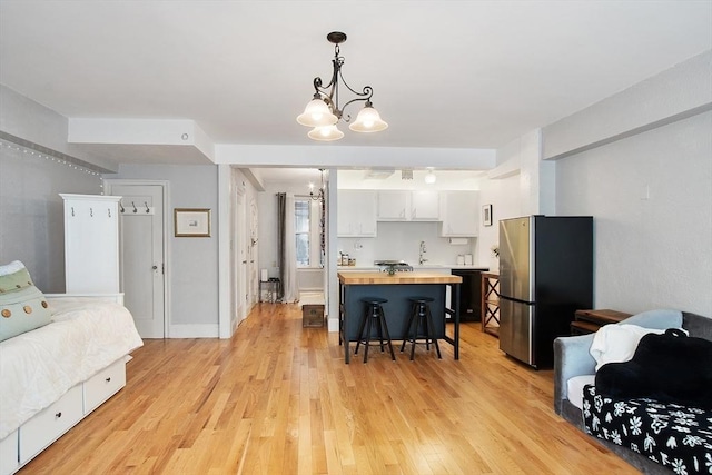 250 Beacon Unit 1B, Boston, MA 02116 - kitchen featuring freestanding refrigerator, wooden counters, a chandelier, light wood-type flooring, and white cabinetry