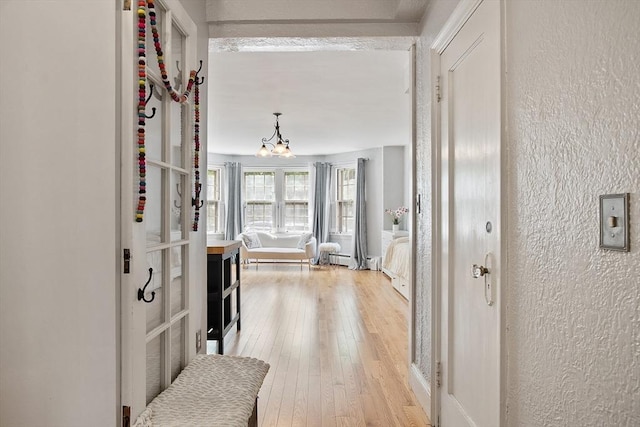 250 Beacon Unit 1B, Boston, MA 02116 - hall with a textured wall, a chandelier, and light wood finished floors