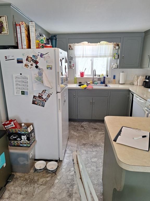 kitchen featuring white appliances, gray cabinets, and sink