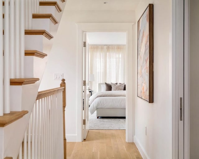 hallway featuring baseboards and light wood finished floors
