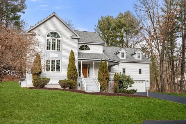 front facade with a porch, a garage, and a front lawn