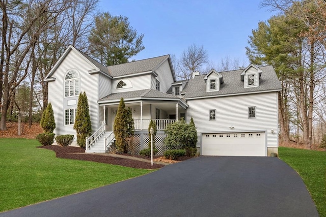 view of front of property with a front yard, a porch, and a garage