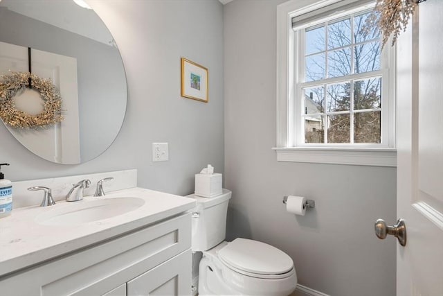 bathroom with vanity, baseboards, and toilet