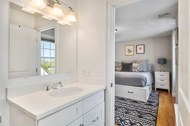 bathroom with visible vents, wood finished floors, and vanity