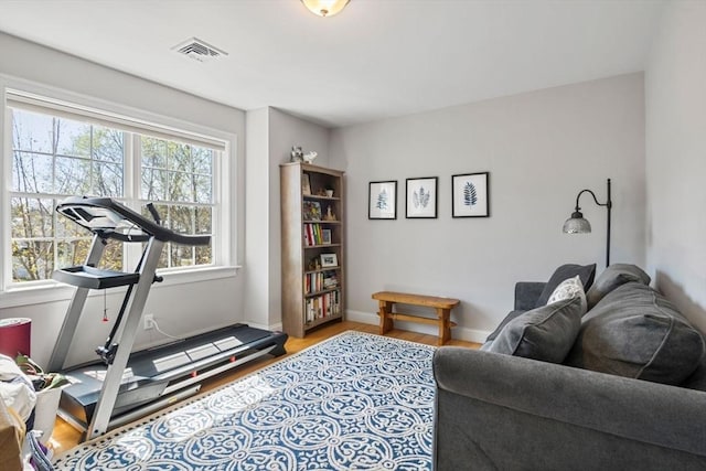 workout area with baseboards, wood finished floors, and visible vents