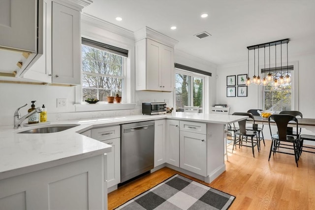 kitchen featuring stainless steel dishwasher, crown molding, visible vents, a peninsula, and a sink