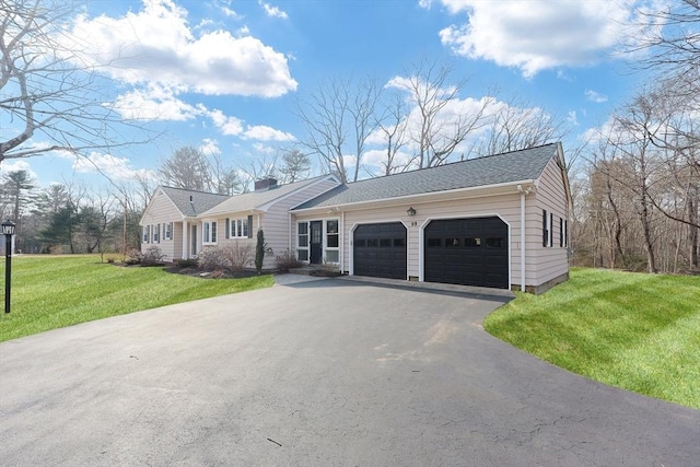 ranch-style house with a garage, a front lawn, a chimney, and aphalt driveway