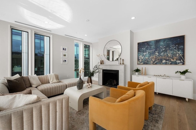 living area with recessed lighting, a fireplace, and wood finished floors