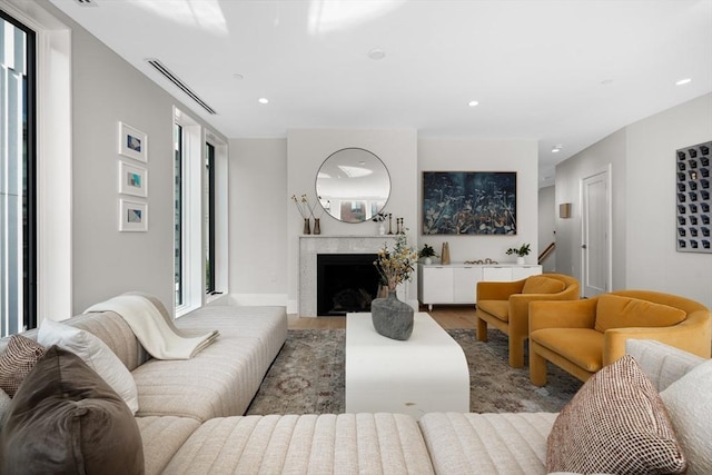 living area featuring a fireplace, visible vents, wood finished floors, and recessed lighting