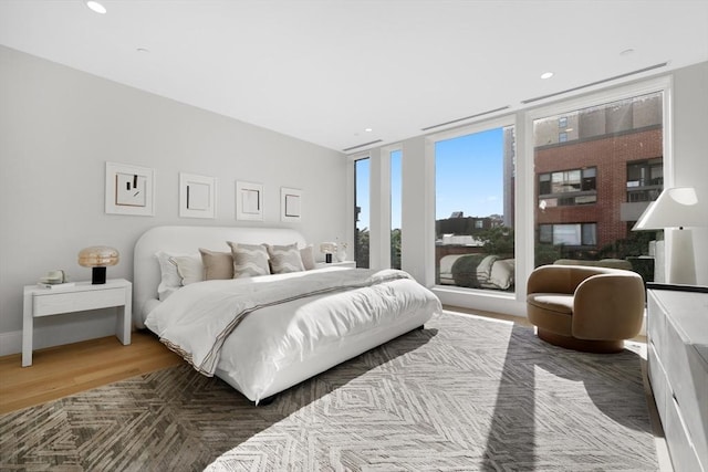 bedroom featuring recessed lighting, wood finished floors, and floor to ceiling windows