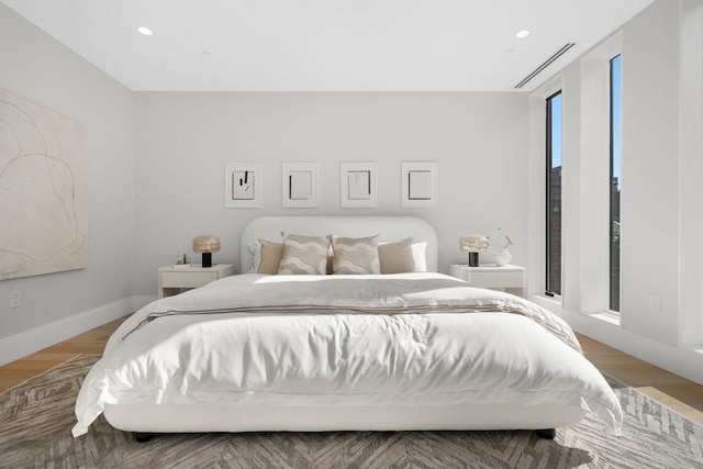 bedroom with baseboards, recessed lighting, visible vents, and light wood-style floors