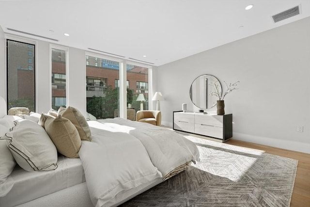 bedroom featuring recessed lighting, wood finished floors, visible vents, and baseboards