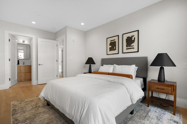 bedroom featuring light wood-style floors, recessed lighting, connected bathroom, and baseboards