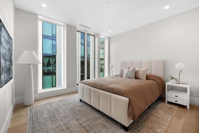 bedroom featuring baseboards, light wood-type flooring, visible vents, and recessed lighting