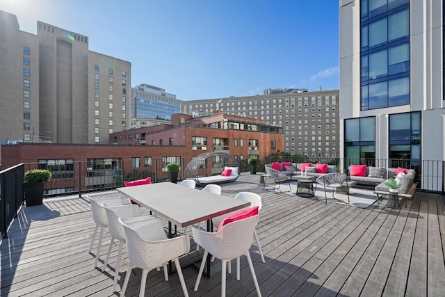 wooden terrace featuring outdoor dining area, a view of city, and outdoor lounge area