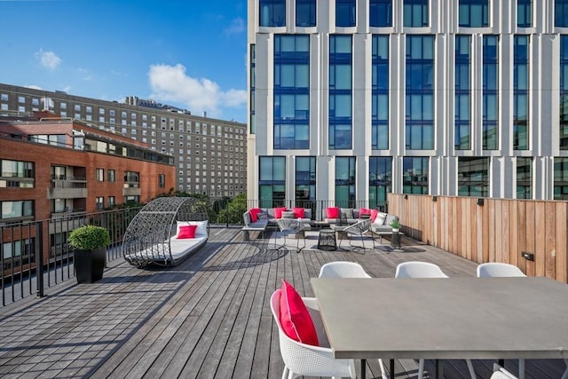 wooden terrace featuring outdoor dining area and a city view