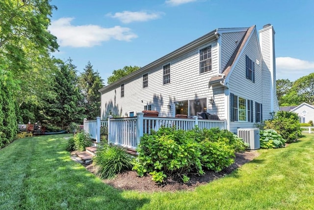 80 Schooner Ln, Barnstable, MA 02601 - back of house featuring central AC unit, a chimney, a lawn, and a wooden deck