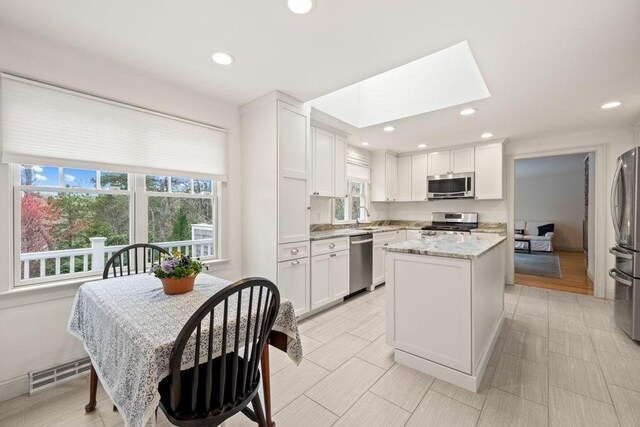307 Riverview Dr, Chatham, MA 02633 - kitchen featuring white cabinets, recessed lighting, visible vents, light stone countertops, and appliances with stainless steel finishes