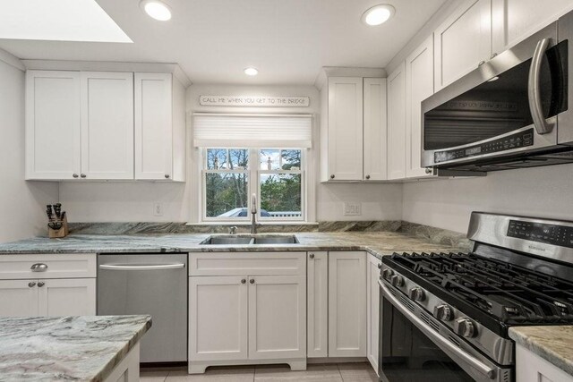 307 Riverview Dr, Chatham, MA 02633 - kitchen with a sink, recessed lighting, white cabinetry, light stone counters, and appliances with stainless steel finishes
