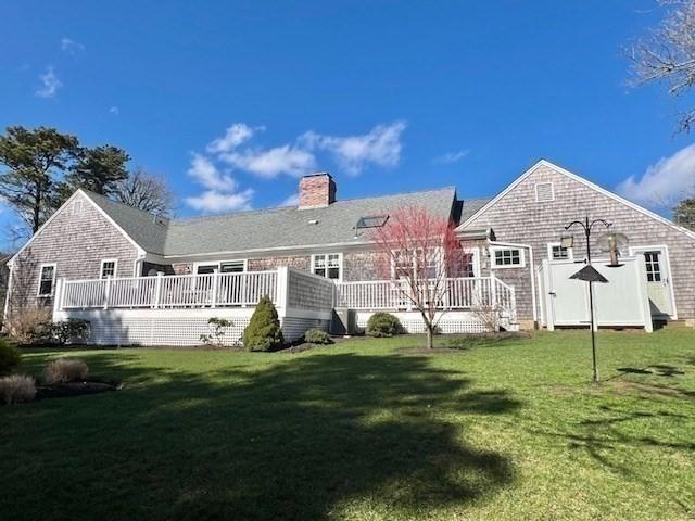 307 Riverview Dr, Chatham, MA 02633 - back of property featuring a lawn, a chimney, and a deck