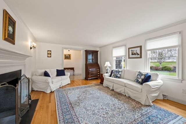 307 Riverview Dr, Chatham, MA 02633 - living room with a fireplace with flush hearth, visible vents, light wood-style floors, crown molding, and baseboards
