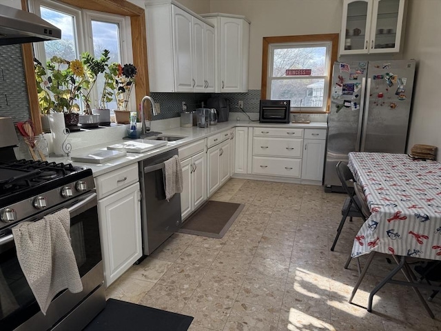 127 Sumner St, Milton, MA 02186 - kitchen with appliances with stainless steel finishes, wall chimney exhaust hood, a sink, tasteful backsplash, and light countertops