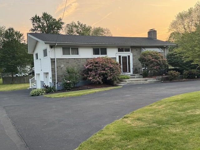 127 Sumner St, Milton, MA 02186 - split foyer home with a chimney, stone siding, driveway, and an attached garage