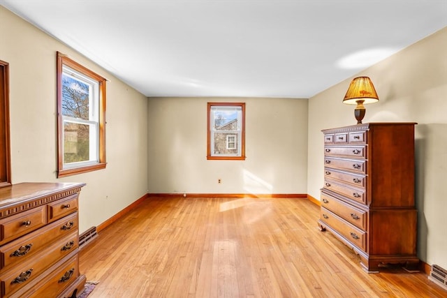 unfurnished bedroom with multiple windows and light wood-type flooring