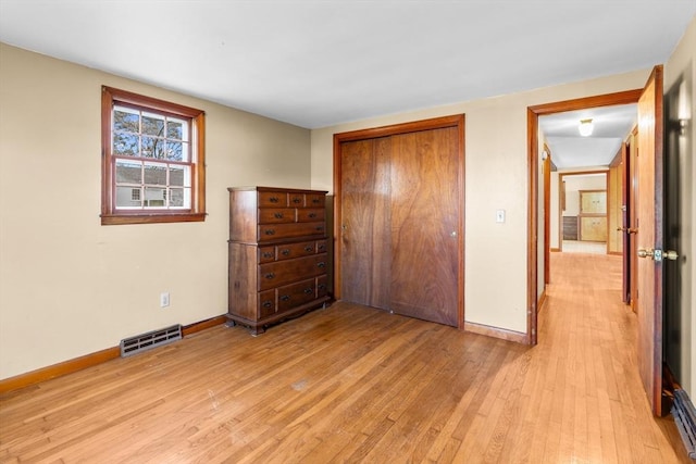 unfurnished bedroom with light hardwood / wood-style flooring and a closet