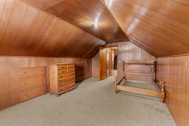 unfurnished bedroom with light colored carpet, wooden walls, lofted ceiling, and wood ceiling