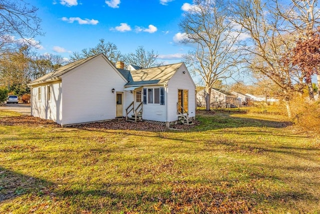 rear view of property with a lawn