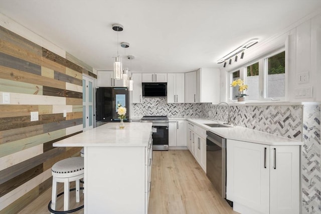 152 Audubon Ave, Braintree, MA 02184 - kitchen featuring stainless steel appliances, a sink, white cabinets, a breakfast bar, and light countertops