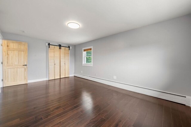 152 Audubon Ave, Braintree, MA 02184 - unfurnished bedroom featuring a barn door, a baseboard radiator, dark wood-type flooring, and baseboards