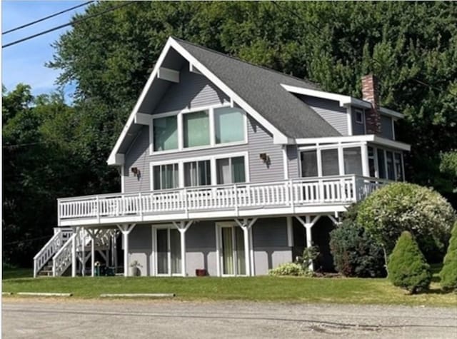 view of front facade with a deck and a front lawn