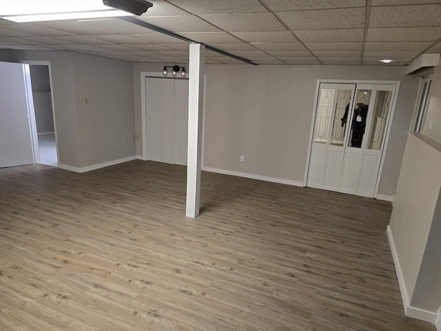 basement featuring a drop ceiling and hardwood / wood-style flooring