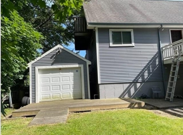 exterior space with a garage, an outdoor structure, and a lawn