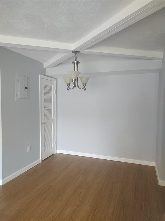 unfurnished room featuring beam ceiling, dark wood-type flooring, an inviting chandelier, electric panel, and a textured ceiling