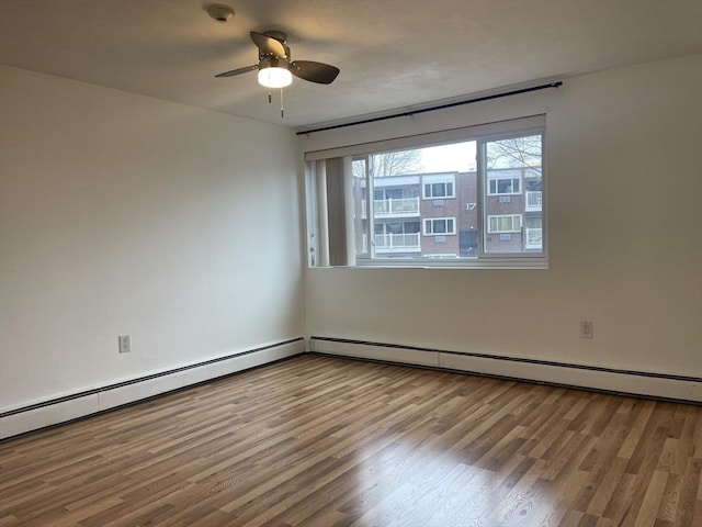 unfurnished room featuring a baseboard radiator, ceiling fan, and wood finished floors