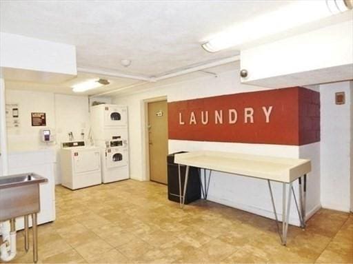 welcome area with stacked washing maching and dryer, washing machine and dryer, and a sink