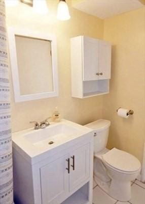 bathroom featuring toilet, tile patterned flooring, and vanity