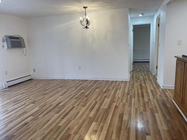 unfurnished dining area featuring an AC wall unit, a baseboard radiator, light wood-style flooring, and baseboards