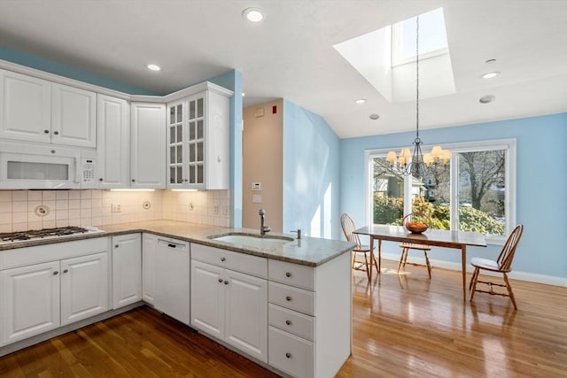 kitchen with sink, white cabinets, and white appliances